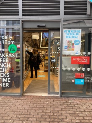 Glass door with grey frame ahead. Doors slides right to open automatically.