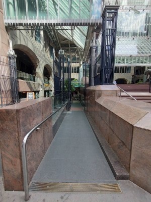 From pavement looking straight. Built-in ramp ahead. Handrail on left.