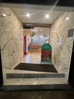 Door slides open to right. A frame sign to right before door.
