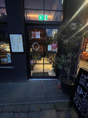 Glass door with black metal frame. Push from left.
