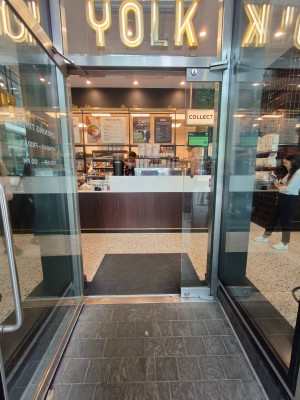 Facing entrance door. Pull silver handle on right of door to open.