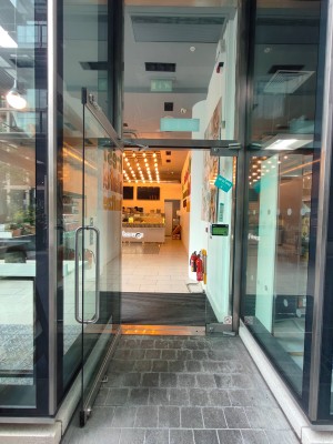 Facing entrance door. Pull silver handle on right of door to open.