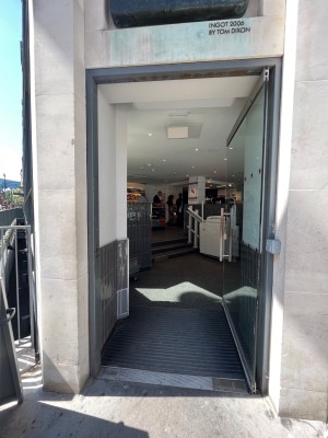 Single glass door in black plastic frame. Push silver metal handle from left to open.