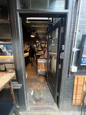 Black framed glass door. Push from left side to open.