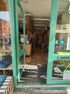 Facing entrance door. Push handle on right of left door to open.