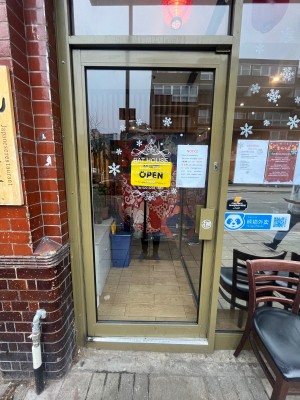 Glass door with brown metal frame. Push from right.