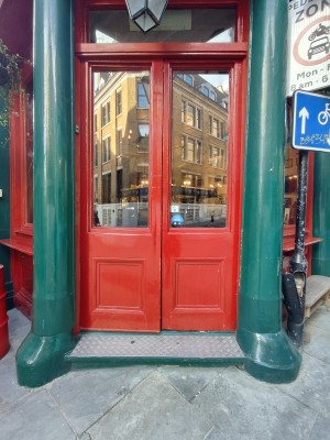 Red framed glass doors. Push from centre to open.