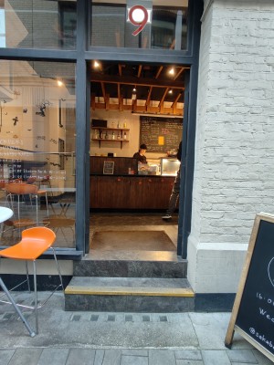 Black framed glass doors. Push golden metal handles in centre to open.