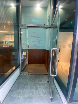 Glass door. Silver handle on left. Pull to open.
