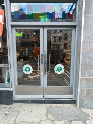 Facing entrance door. Push handles in centre to open.