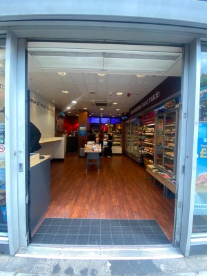Double glass door, with metal grey doorframe. Handles at centre. Slide from centre to sides to open.