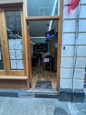 Single glass door in brown wooden frame. Push from right to open.