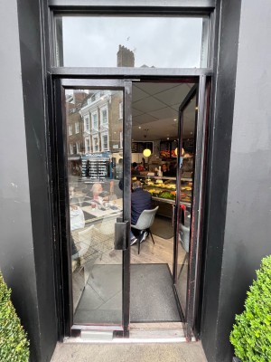 Black framed glass doors. Push open via handles in centre.