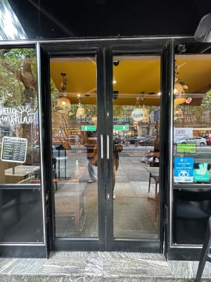 Glass sliding doors with black doorframe. Silver vertical handles in centre of doors. Slide open from centre to open.