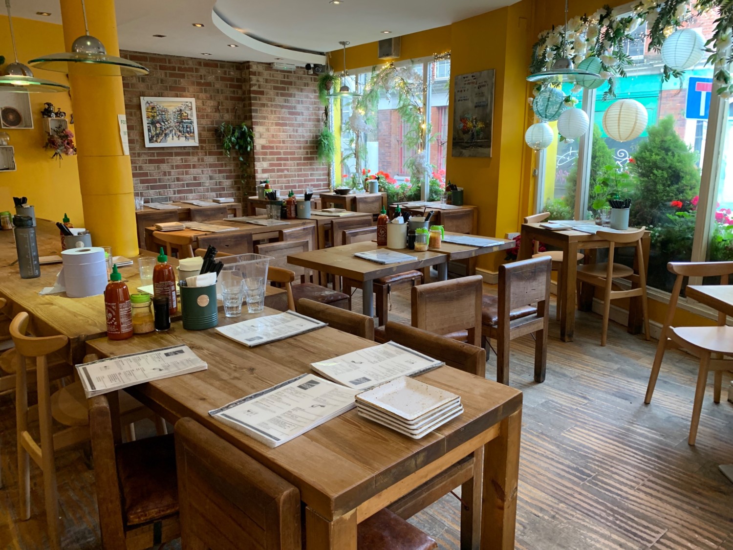 From beginning of counter, looking straight. Tables and chairs dispersed ahead and along right and back walls.