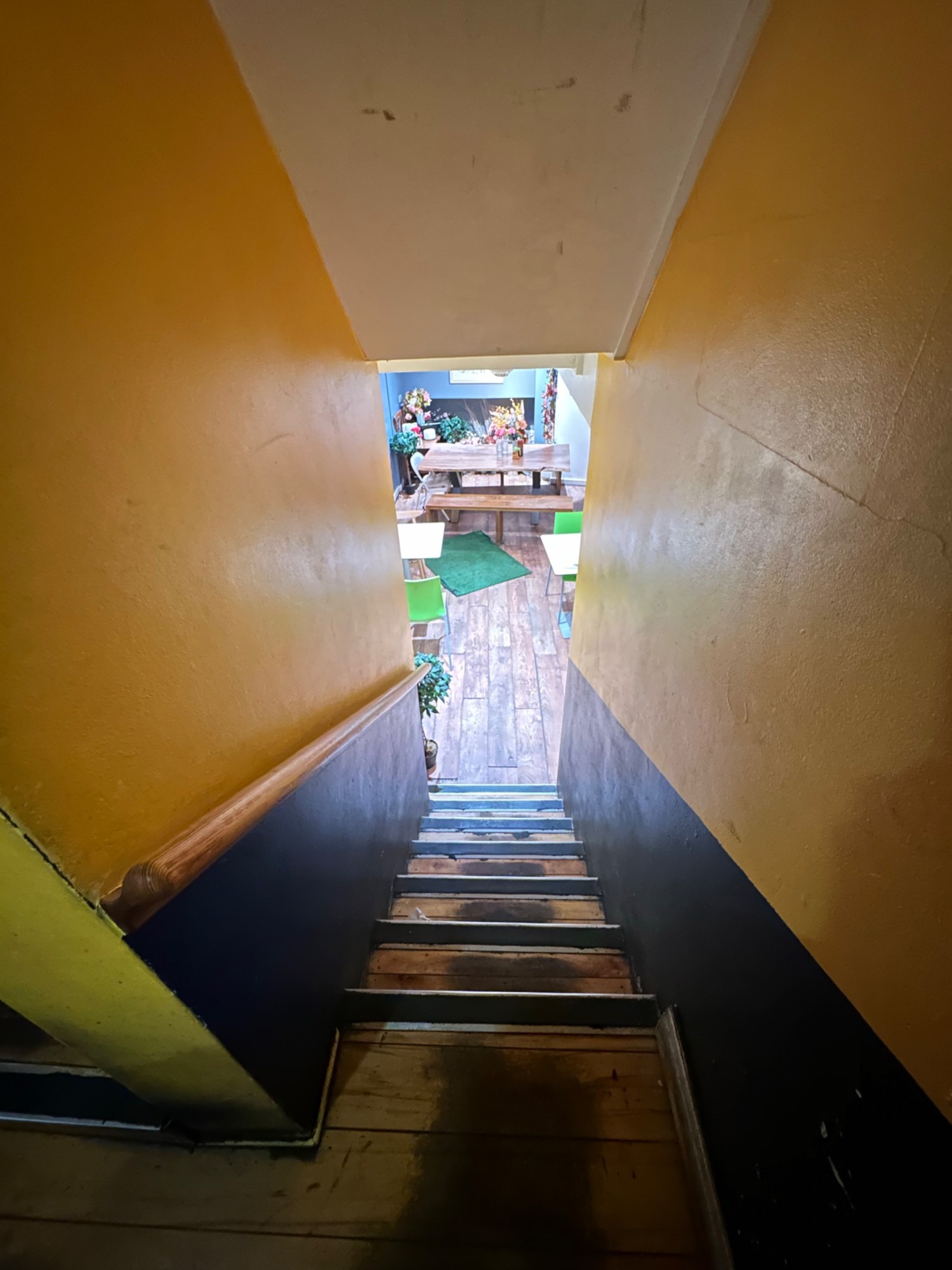 From end of landing looking left at second flight of stairs straight ahead. Wooden handrail on left.