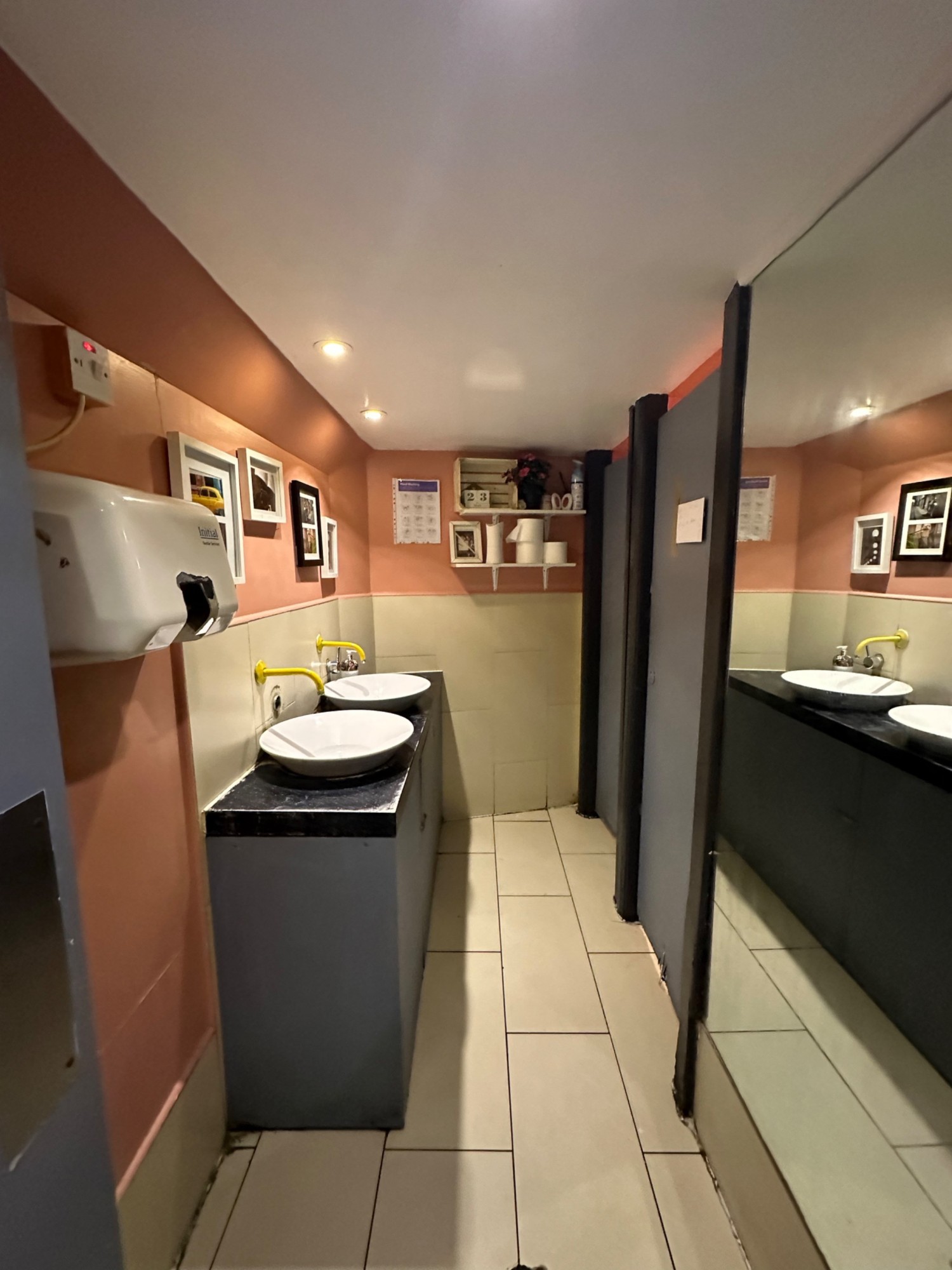 From door looking straight at sinks to far left. Cubicles to far right.