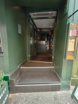 Facing entrance door. Two steps ahead to double doors. Push handles in centre to open.