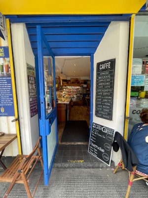 Blue door with glass panel, handle at right. Pull to open. Display board at right.