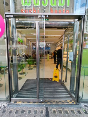 Facing entrance door. Push silver metal handles in centre of door to open.