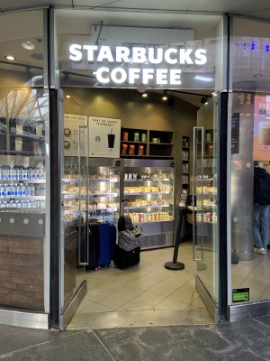 The entrance has two glass double doors with fridges with food and drinks in front, and the main order area to the right hand side.