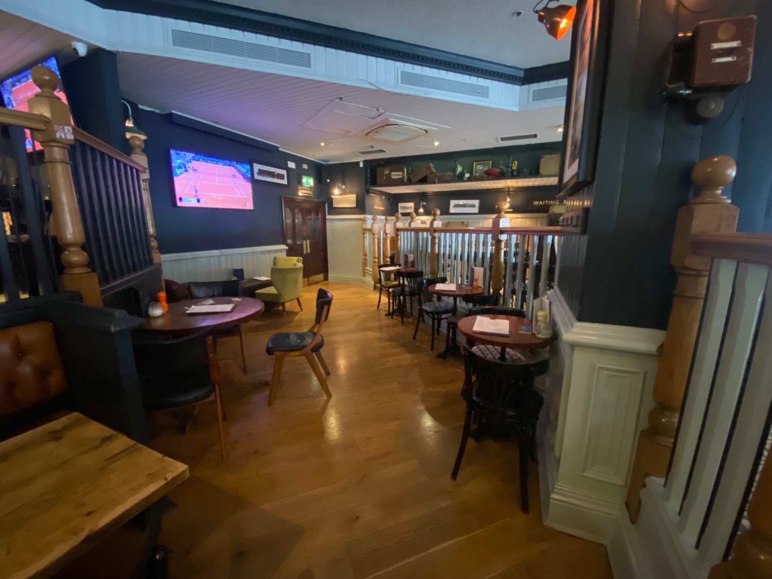 From half booth, facing right. Tables and chairs on both sides. Path ahead in front.