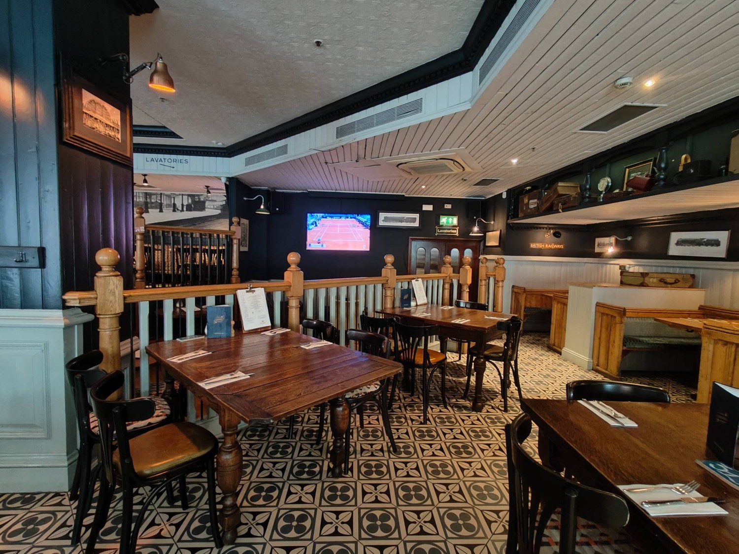 From mid left path facing left. Tables and chairs along back wall. Booths along the back right.