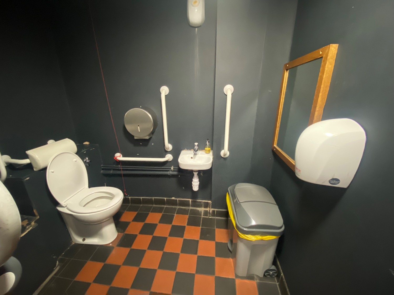 From door, facing straight. Sink in front. Toilet on left.
