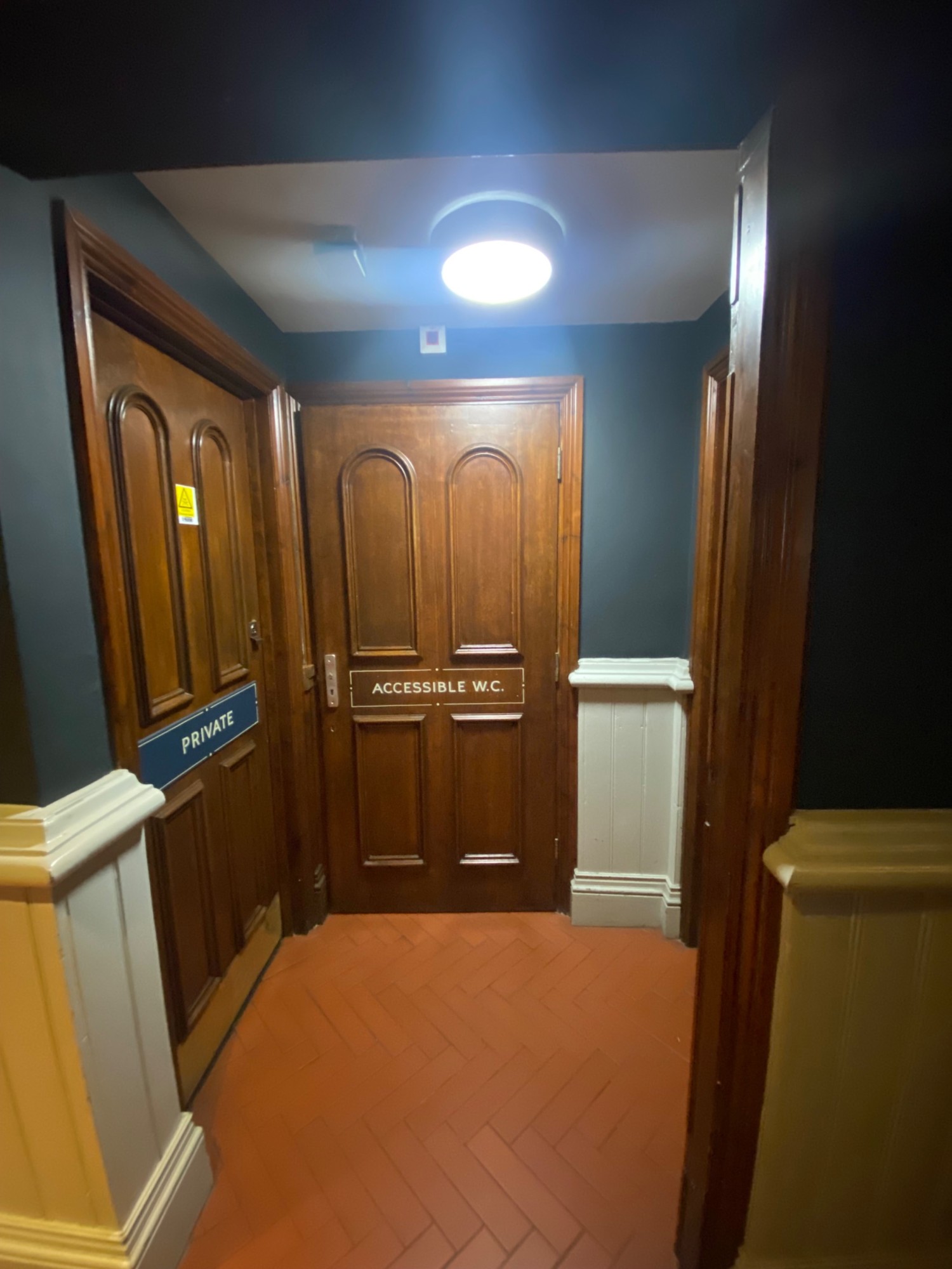 From door, facing right. Archway in front. Toilet door after archway. Wooden door, radar keyhole on left. Pull to open.