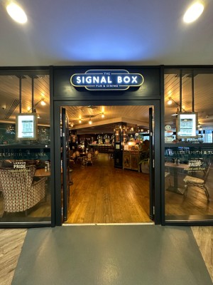 Glass doors with black doorframe. Black handles in centre of doors. Push to open.