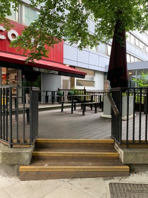 From sidewalk facing venue. Staircase ahead. Handrail along right side.