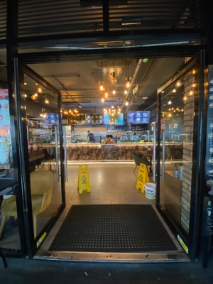 Double glass door, with black doorframe. Handles at centre of door. Push to open.