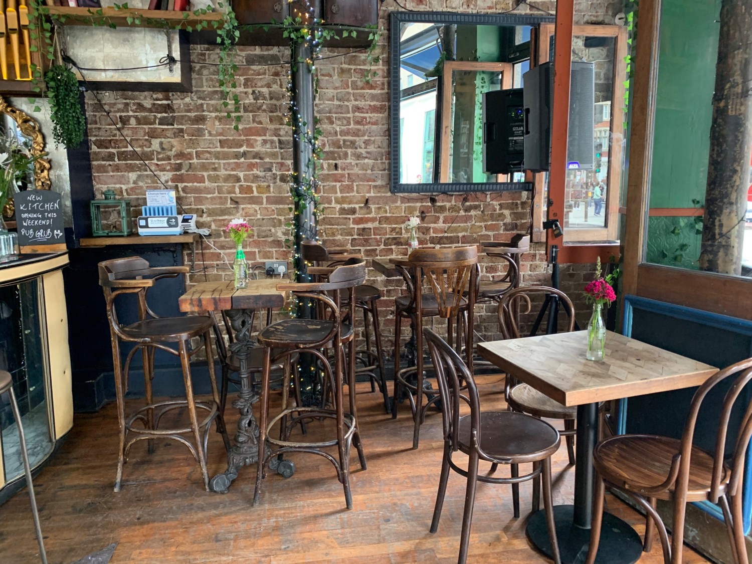 From entrance, looking right. Table and chairs on right. High tables and stools along back wall. Beginning of counter on left.