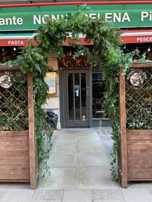 The entrance is on the street through an archway which encloses the outdoor seating area from the street, straight ahead to the single doorway which pushes to open using a high handle on the right hand side. There is a small bump on the threshold of the door.