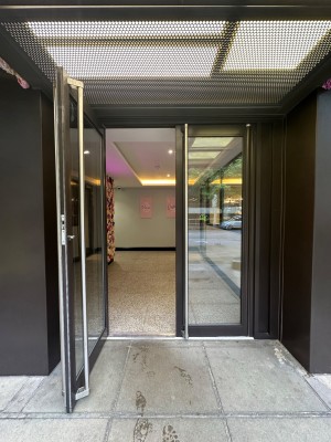 Glass doors with black doorframe. Silver vertical handles in centre of door. Pull to open.