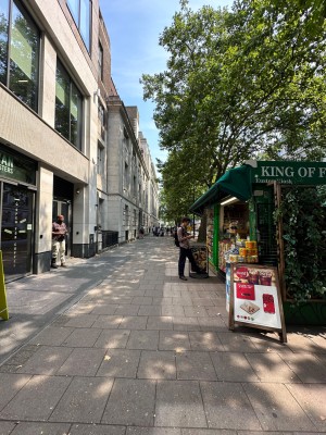 From pavement, facing straight. Kiosk on left.