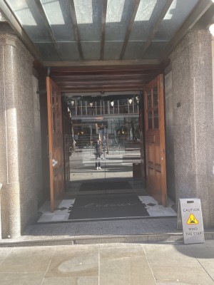 View of main entrance from the street. There is a small step, followed by two sets of double doors.