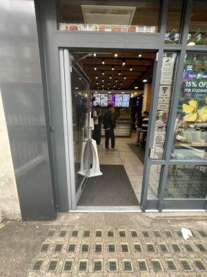 Glass door with black frame, handle at right. Push button at right to open.