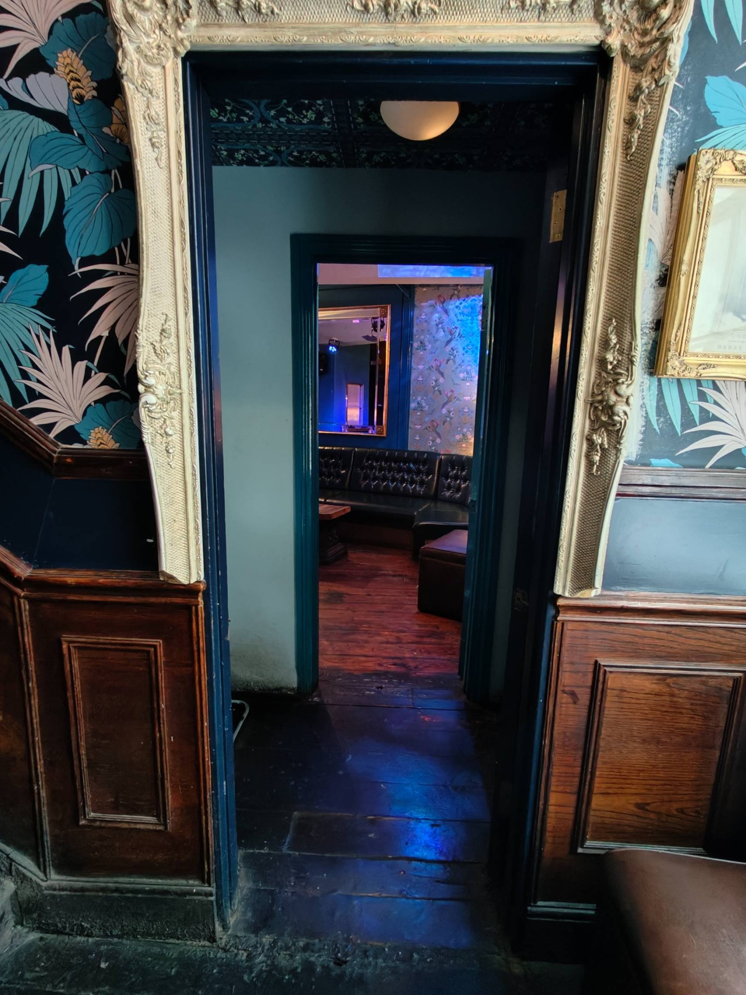 From top of steps facing left. Blue door to seating area. Push golden metal handle on left to open.