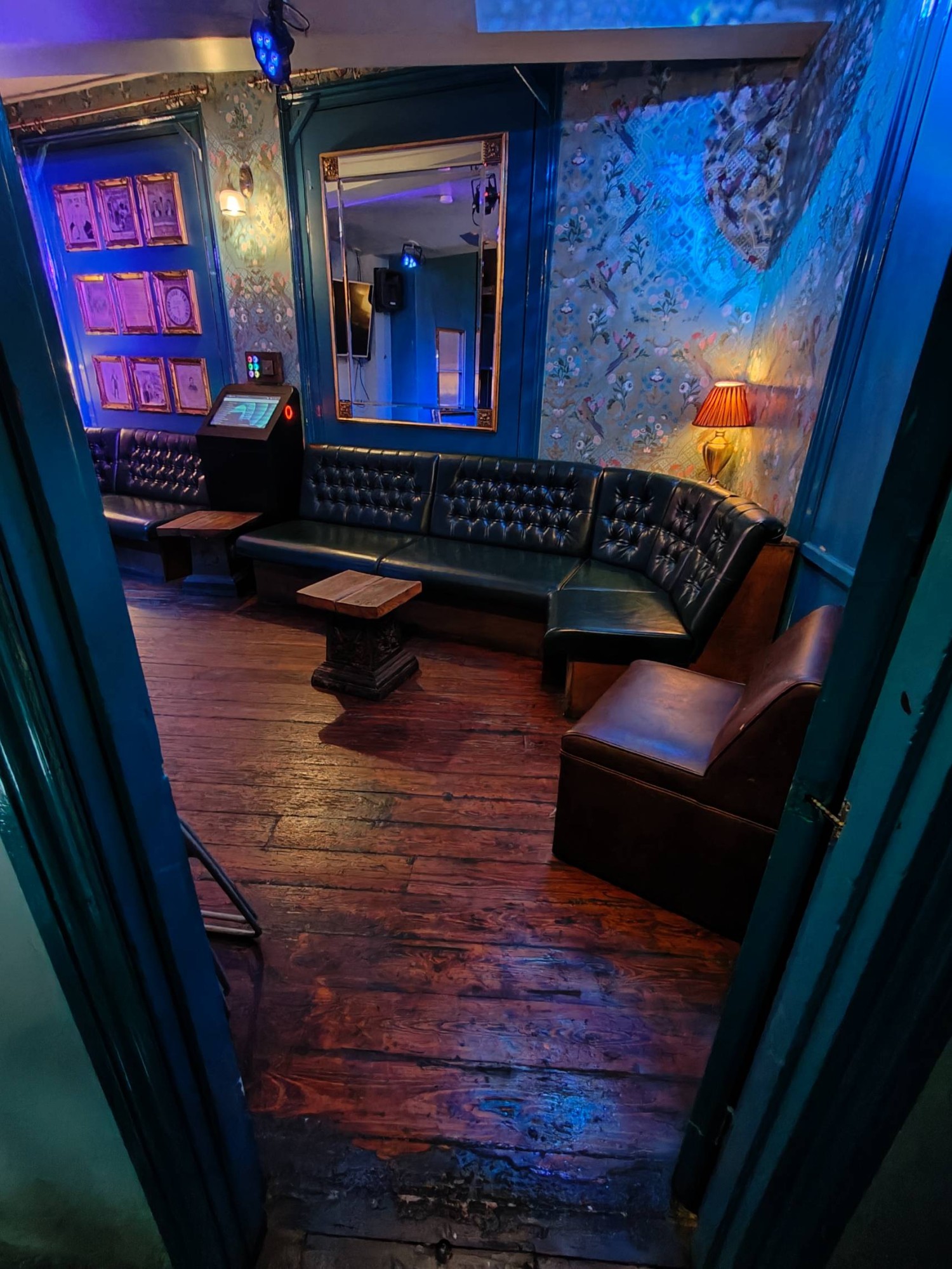 From door facing straight. Blue framed door to seating. Push golden metal handle on left of door to open.