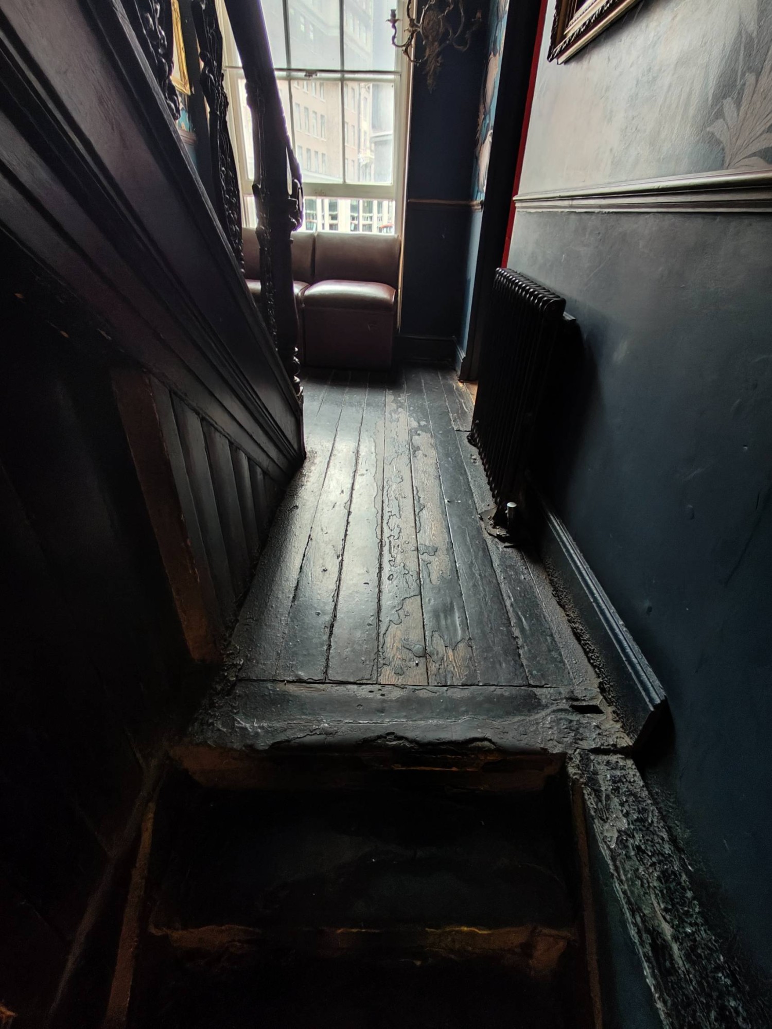 From top of stairs facing straight. Two steps up to path going straight. Chairs along back glass wall.