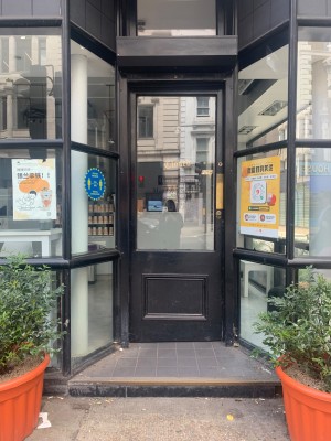 Single black wooden door with glass panel. Push from right of door to open.