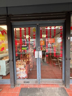 Double glass doors with black frame ahead. Pull at center left of right door to open.