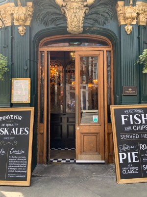 Double glass doors with brown wooden frames. Push from center to open.