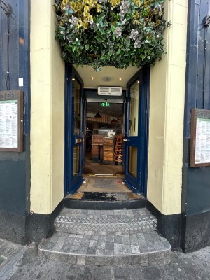 Blue framed glass door ahead. Push handle from middle to open.