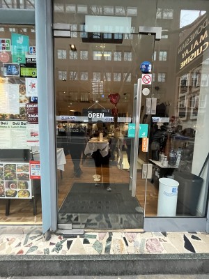 One large step to manual glass door (handle on right) push to open door