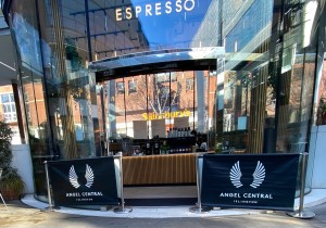 Glass automatic doors ahead. Restaurant barriers on either side of entrance.