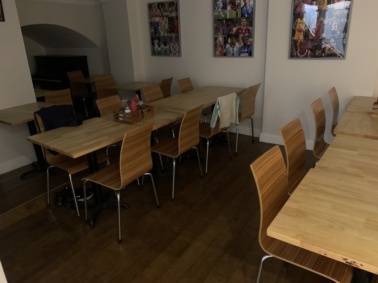 Seating to the left from the stairs with wide paths between rows of tables, running perpendicular from the left side wall.