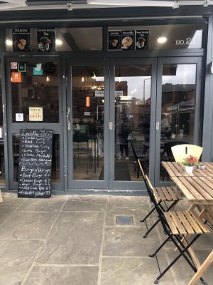View from the entrance. The door has a handle on the left hand side that needs to be pull to enter the space. There is a small step. There are two glass doors after the main door.