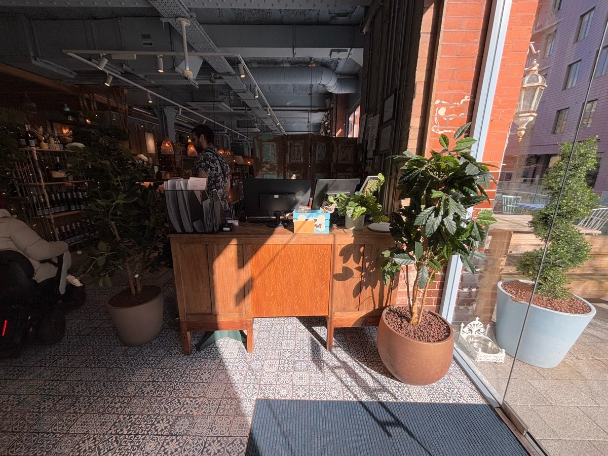 From entrance facing right. Welcome desk ahead. Planter at right.